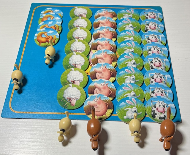 Alcuni elementi del gioco: le tessere che rappresentano gli animali e i cani in plastica
